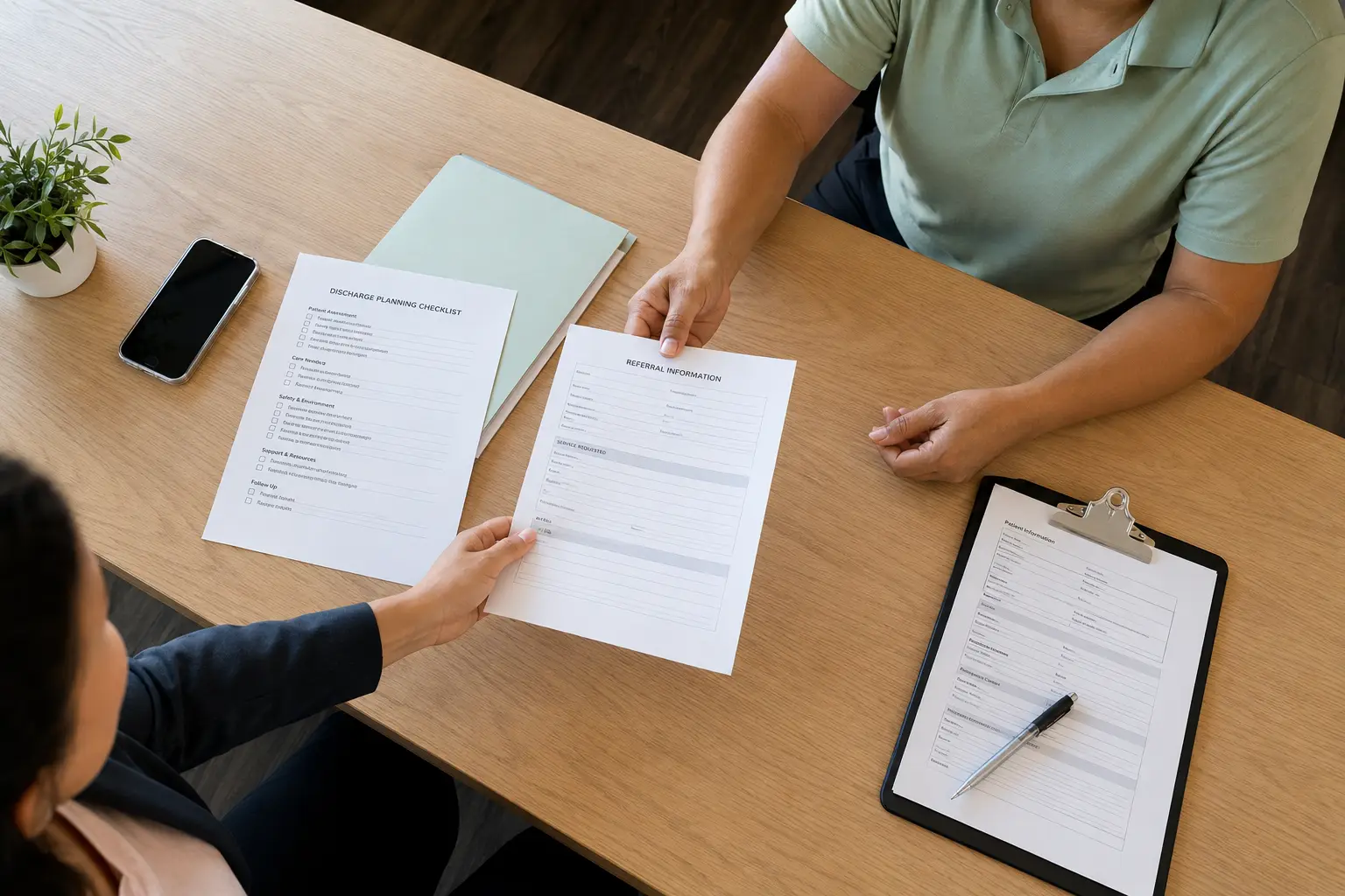 Referral paperwork passed across a desk to a Kai Home Care representative